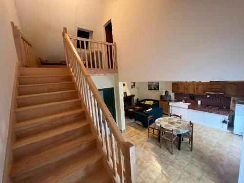 een trap in een woonkamer met een tafel en een keuken bij Gîte Fuchsia in Carlux