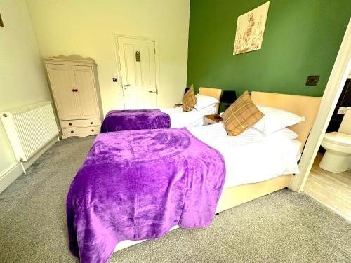 two beds in a room with purple blankets at Greendale Teahouse and Rooms in Chatburn