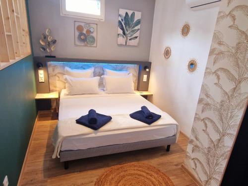 Un dormitorio con una cama con toallas azules. en Le Platinium Barachois en Saint-Denis