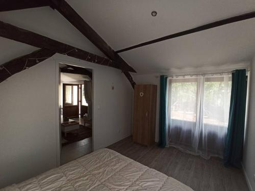 ein Schlafzimmer mit einem Bett und einem großen Fenster in der Unterkunft Magnifique pigeonnier rénové classé 3 étoiles in Catus