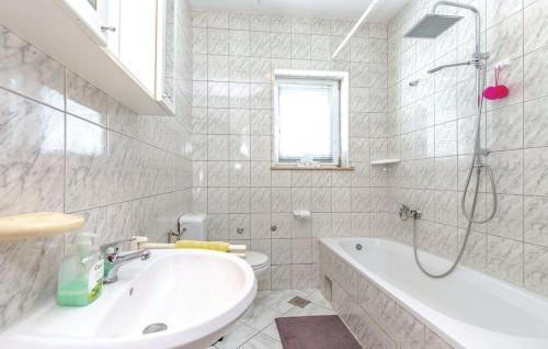 La salle de bains blanche est pourvue d'une baignoire et d'un lavabo. dans l'établissement Apartman Mila, à Novi Vinodolski