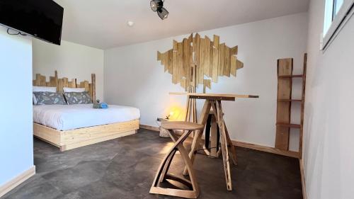 a bedroom with a bed and a wooden desk at Hôtel En Tilleul in Pont-du-Navoy