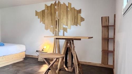 a room with a table and a stool and a bed at Hôtel En Tilleul in Pont-du-Navoy