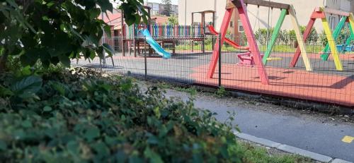 a playground with colorful swings and a play area at Alice Apartment in Arad