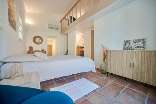 une chambre avec un lit blanc et une armoire en bois dans l'établissement Les Cyprés du Sud Villa 10 personnes Piscine Golfe de Saint-Tropez Gassin, à Gassin