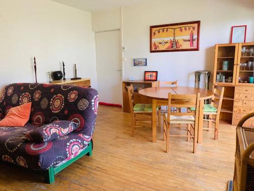 un salon avec un canapé et une table dans l'établissement Au Chêne tranquille - côte landaise, à Parentis-en-Born