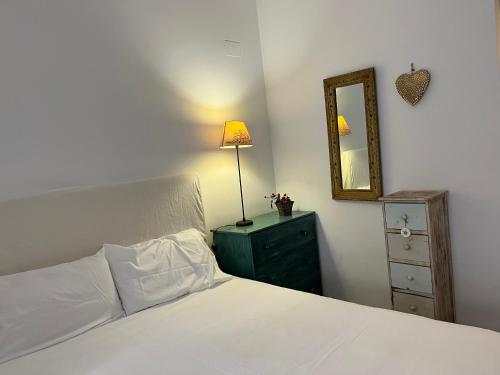 ein Schlafzimmer mit einem Bett mit einem Spiegel und einer Kommode in der Unterkunft Bonito bajo con gran terraza in San Juan de Alicante