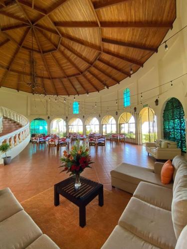 a large room with couches and tables and a large ceiling at Hotel Delfin Playa Bejuco in Esterillos Este