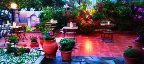 a patio with tables and potted plants and tables and chairs at Nefeli Studios in Loutra Edipsou