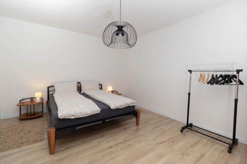 um quarto com uma cama e um lustre em Apartman Beli em Vinkovci