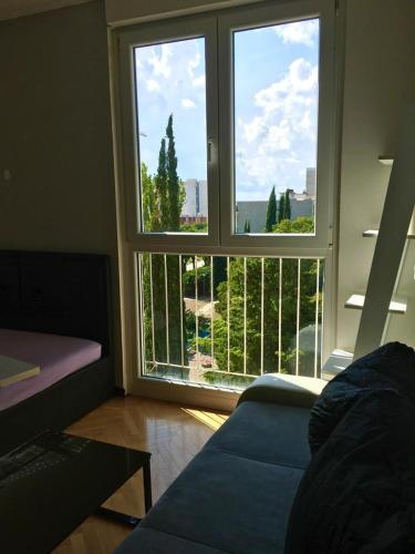 sala de estar con 2 ventanas grandes y sofá en Apartment Victoria, en Split