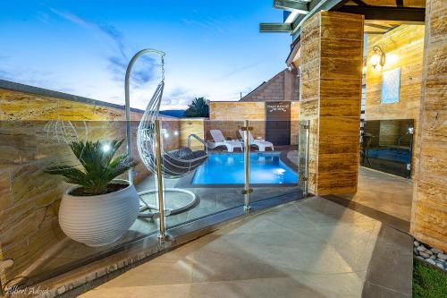 a pool in a house with a plant in a vase at פסגת חד נס - סוויטות יוקרה in Had Nes