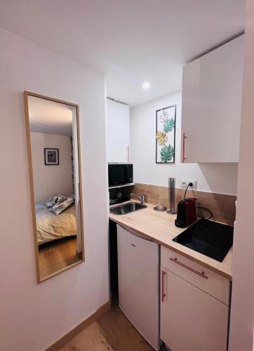 - une petite cuisine avec un évier et un miroir dans l'établissement Rouen Saint Nicaise, à Rouen