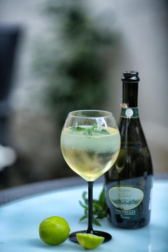 a glass of white wine next to a bottle at Hotel Diandra in Eforie Nord