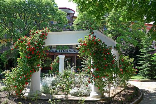 a flower garden in front of a building with red flowers at Hotel Estreya Palace in Saints Constantine and Helena