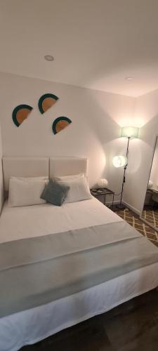 um quarto com uma grande cama branca com duas faces na parede em Nazaré Apartment 2 na Nazaré