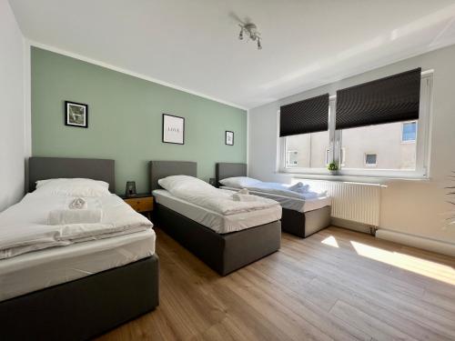 een slaapkamer met 2 bedden en een raam bij Sali - R3 - Apartmenthaus, WLAN, TV in Remscheid