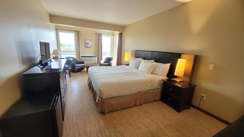a hotel room with a large bed and a television at Hôtel Aquamer in Carleton sur Mer