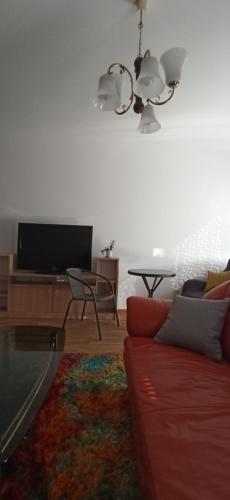 a living room with a red couch and a tv at Aurora in Subotica