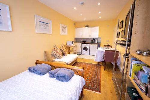 a room with a bed and a couch and a kitchen at London Vegetarian Smoke & Pet Free En-suite with EV parking in Stone Grove