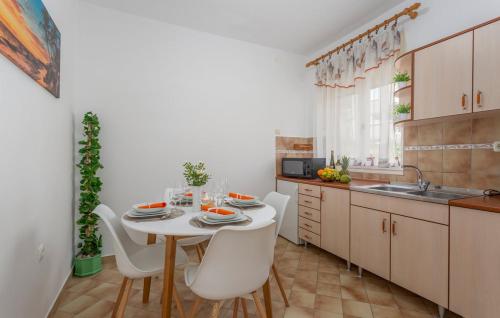 een keuken met een witte tafel en witte stoelen bij Apartmani Marini in Opatija