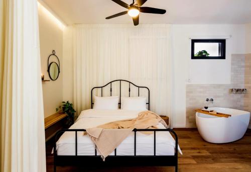 a bedroom with a bed and a bath tub at jabotinsky 37 in Zikhron Ya‘aqov