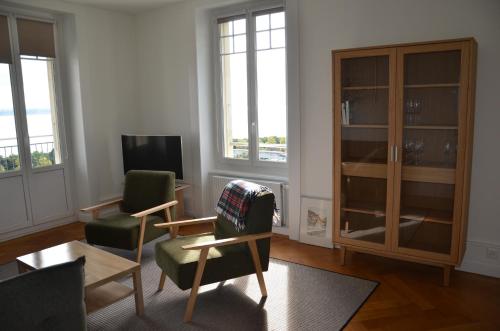 a living room with two chairs and a tv at Appartements Vacances Saars 33 in Neuchâtel
