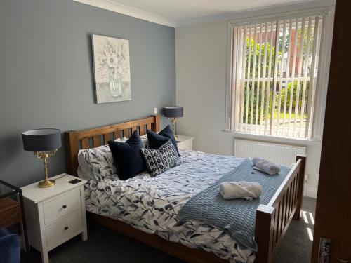 a bedroom with a bed with pillows and a window at The Snicket Apartment in Basingstoke