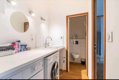een badkamer met een wastafel en een wasmachine bij Appartement luxe "La providence" , plein centre in Vichy