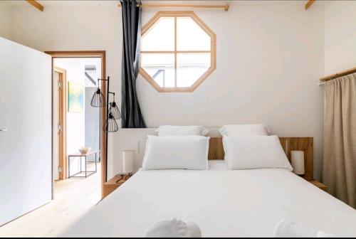 a bedroom with a large white bed with a window at Appartement luxe "La providence" , plein centre in Vichy