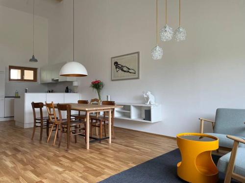 a dining room and kitchen with a table and chairs at Gamsfels Petronella Galeriewohnung in Langen bei Bregenz