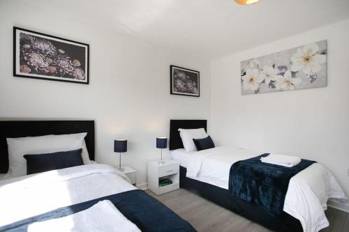 a bedroom with two beds and two pictures on the wall at Maltby House, Rotherham, for contractors, families & Biz in Rotherham