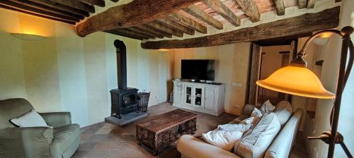 a living room with a couch and a wood stove at Infinity pool villa - Fonte Piccola in Città di Castello