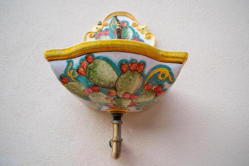 a decorative bowl on a wall with aumedumed at B&B La Manica in Milazzo