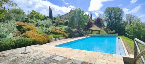 a swimming pool in the middle of a garden at Infinity pool villa - Fonte Piccola in Città di Castello