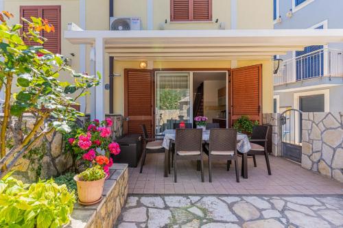 a patio with a table and chairs and flowers at Apartman Bruna in Cres