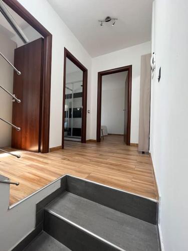 an empty room with wooden floors and doors at Welcome Home Quartu Sant'Elena in Quartu SantʼElena