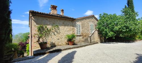 a stone house with potted plants on the side of it at Infinity pool villa - Fonte Piccola in Città di Castello