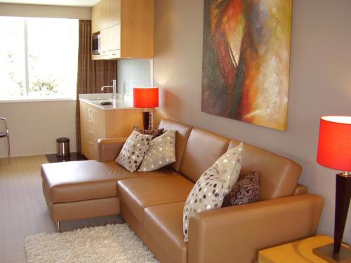 a living room with a couch and a kitchen at Brentwood Hotel in Wellington