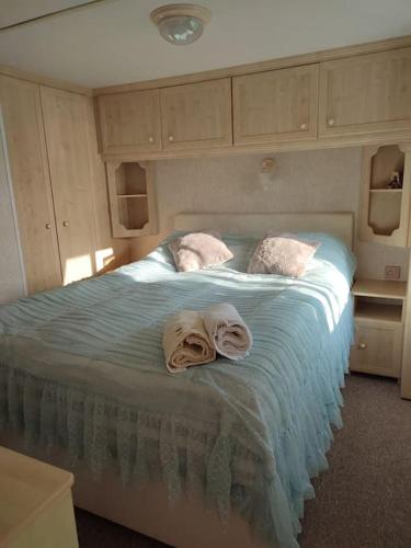a bedroom with a bed with towels on it at DOMEK NAD JEZIOREM in Żywki