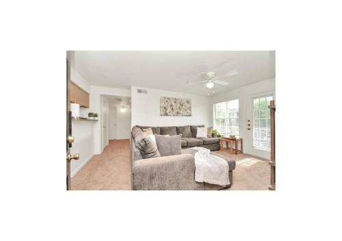 a living room with a couch and a ceiling fan at Luxury 2 Bedroom Apartment with Balcony at Heights - Sleeps 4 in Houston