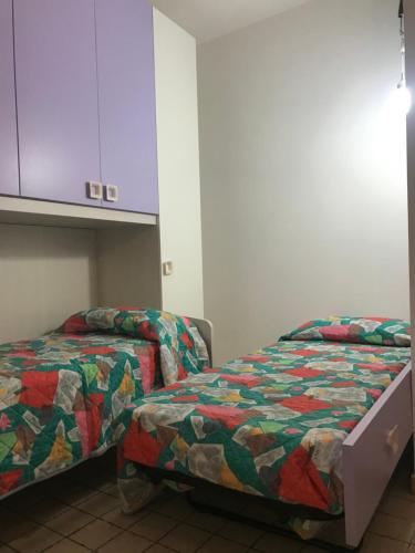 NulviにあるIntro e idda casa vacanzaのベッド2台とキャビネット付きの部屋