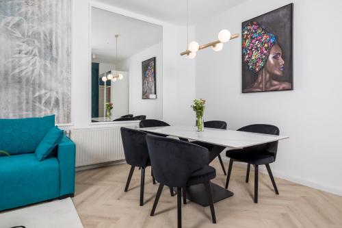 a dining room with a blue couch and a table and chairs at Apartments Madeleine in Rijeka