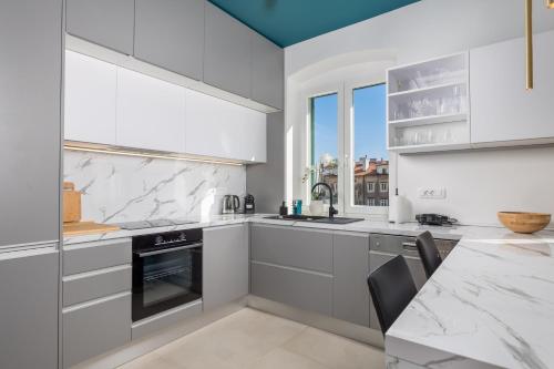 a kitchen with white cabinets and a counter top at Apartments Madeleine in Rijeka