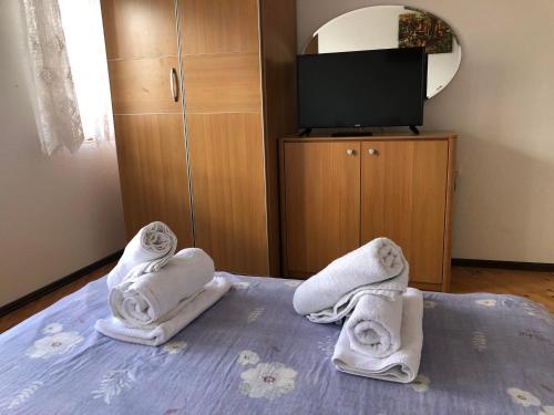 Zimmer mit Handtüchern auf einem Bett und einem TV in der Unterkunft Apartments Veronika in Ohrid