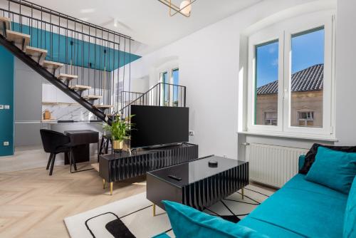 a living room with a blue couch and a staircase at Apartments Madeleine in Rijeka