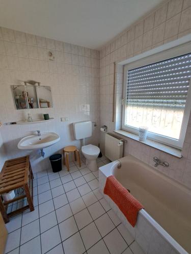 een badkamer met een bad, een toilet en een wastafel bij Ferien am Wieter in Northeim! in Northeim