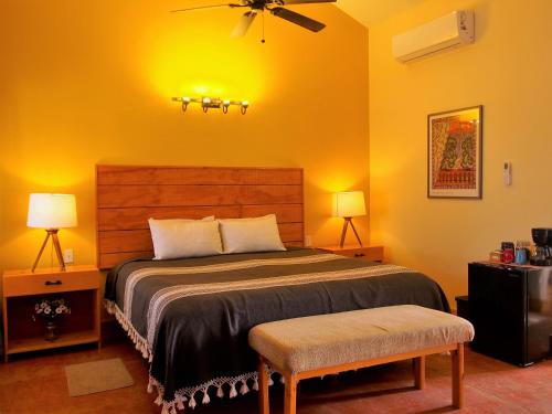 a bedroom with a large bed with yellow walls at Casa Mayoral B&B Pet friendly in Valle de Guadalupe