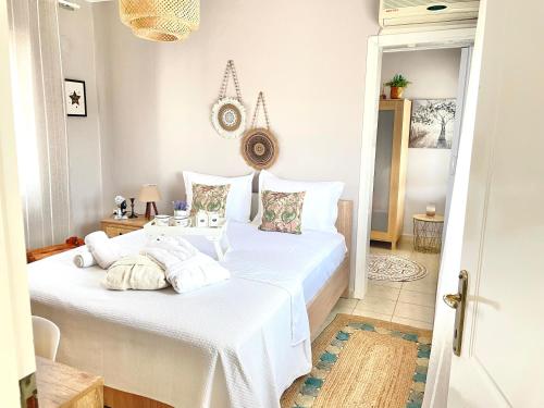 a bedroom with a bed with white sheets and pillows at Davanti al Mare in Epanomi
