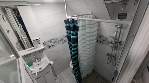 a bathroom with a shower curtain and a sink at Glossy private apartment in Sarajevo